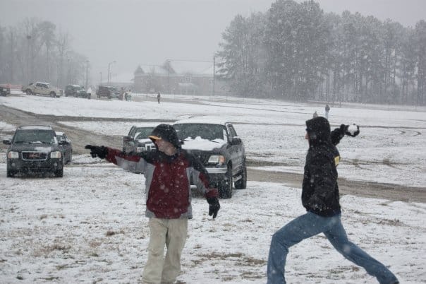 Jordan is about to blindside Andrew with a snowball from a few feet away.