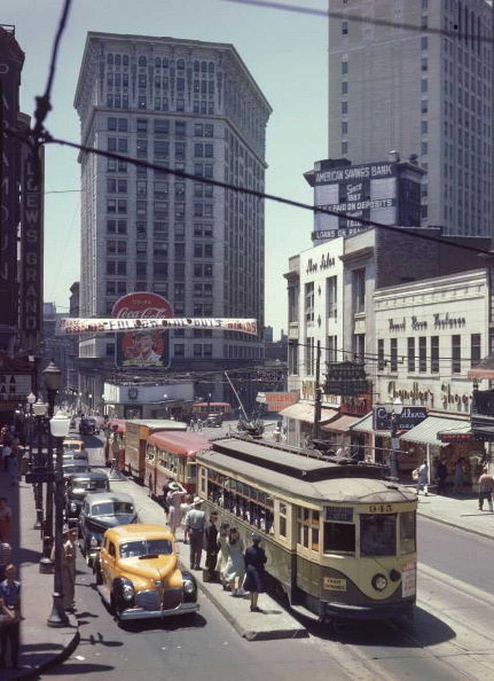 Vintage color photo of a downtown Atlanta street with a streetcar, yellow taxi, Coca-Cola sign and Loew's Grand theater