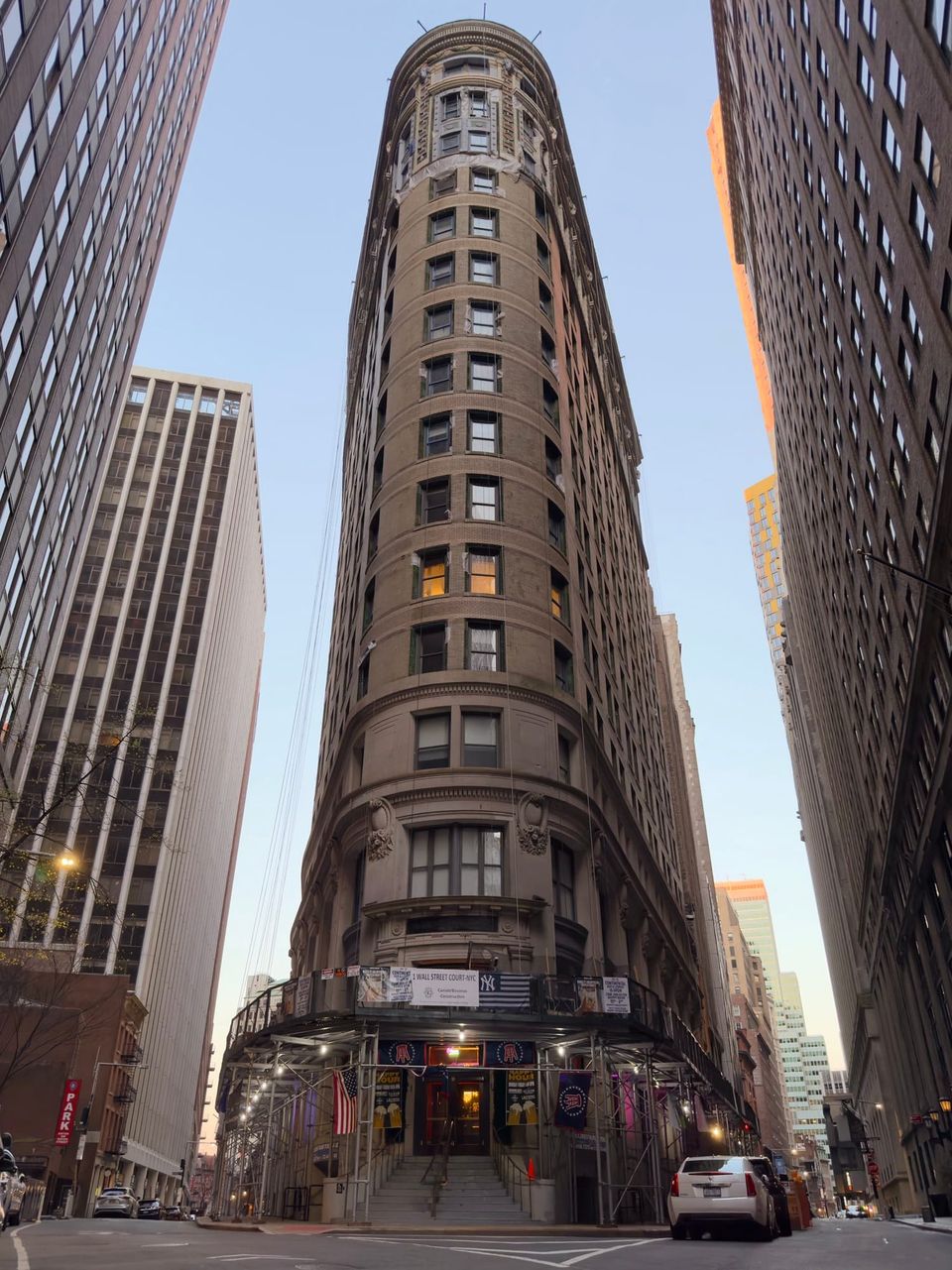 Curved brick tower at 1 Wall Street Court with a Yankees banner over scaffolding