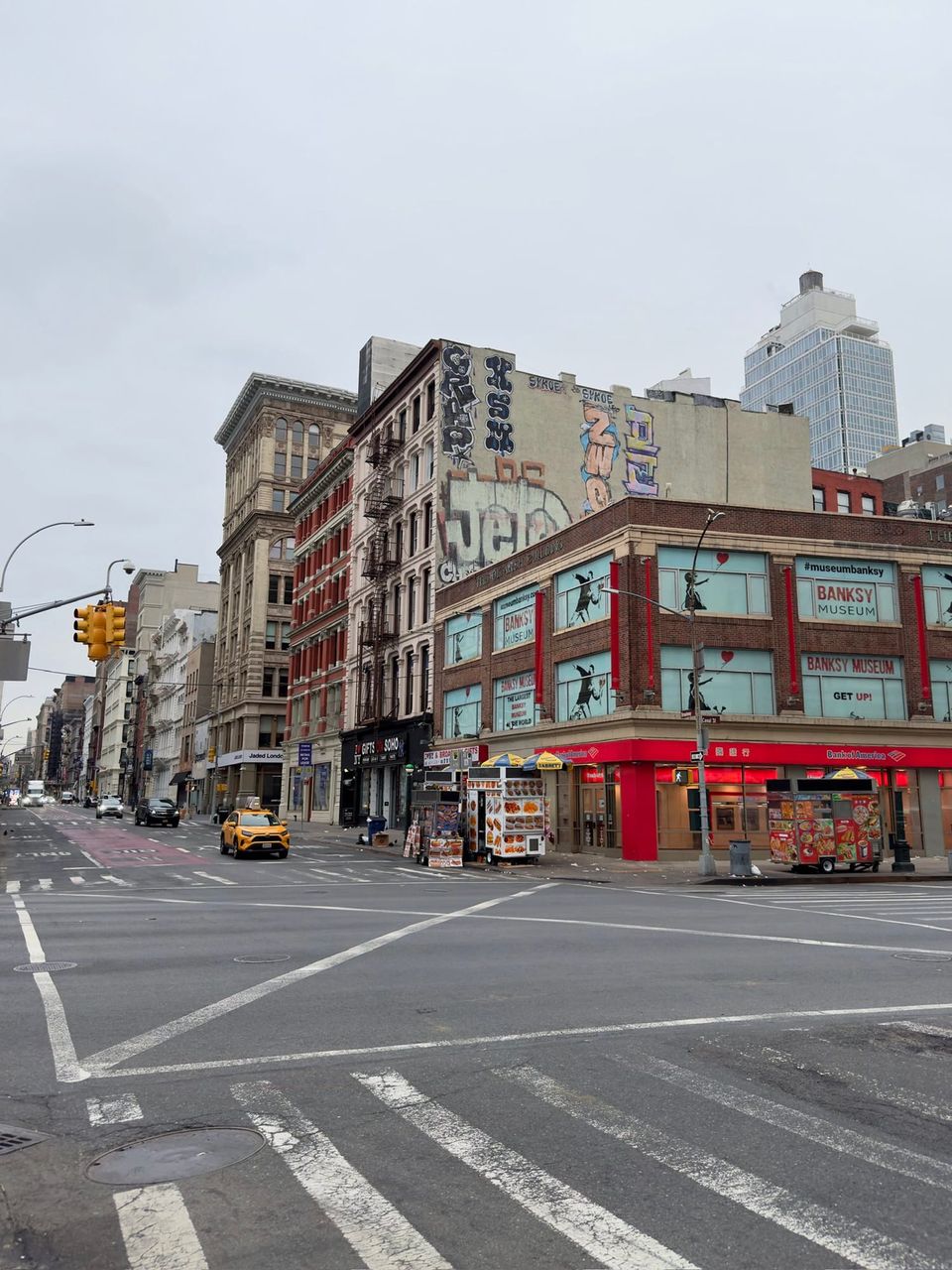 Canal and Broadway corner with a Banksy Museum, graffiti and food carts