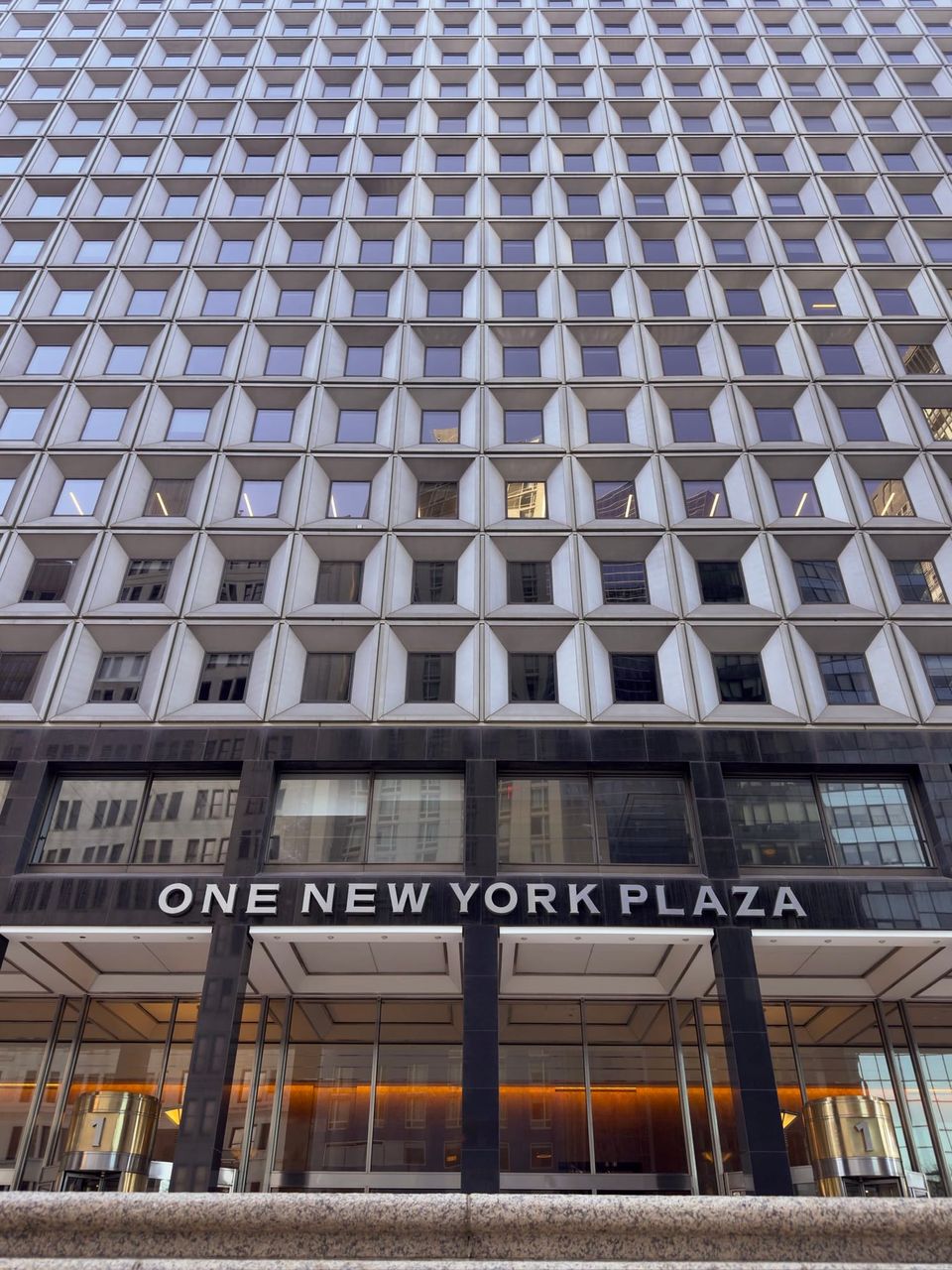 Grid of recessed square windows above the One New York Plaza sign