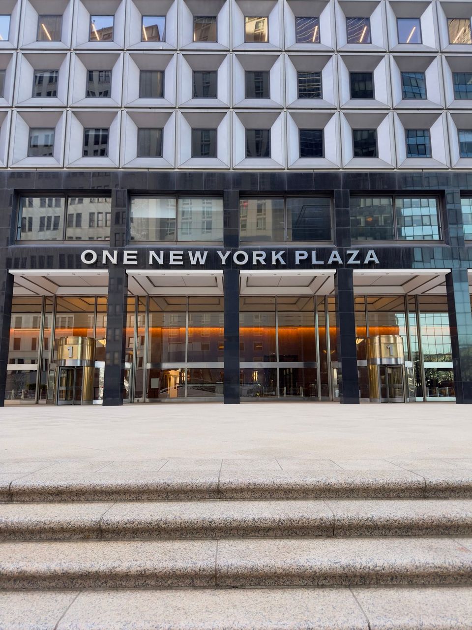 One New York Plaza entrance with brass revolving doors and granite steps