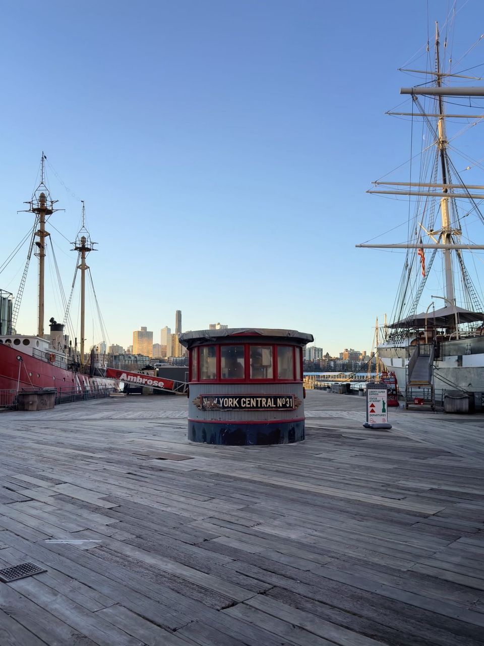 Wooden pier with a New York Central No 31 pilothouse between the Ambrose and a tall ship