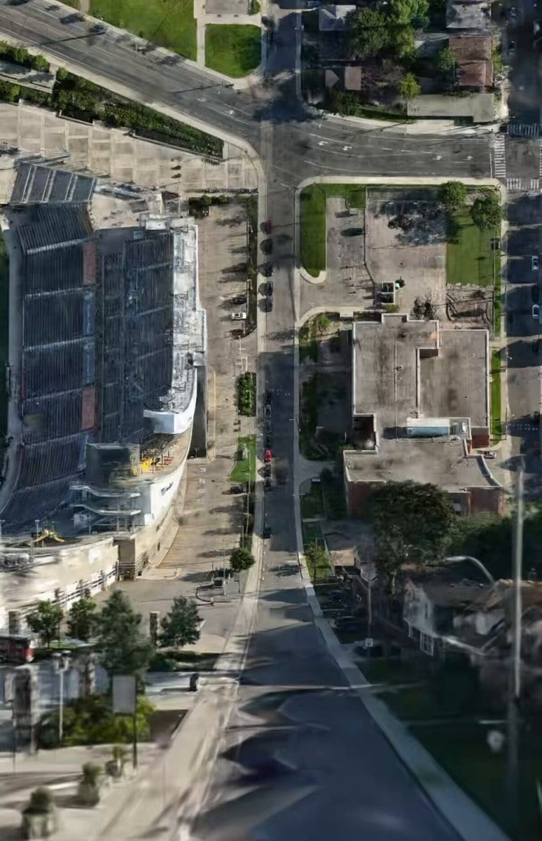 Aerial map view that curves upward like Inception, showing a stadium and streets bending into the distance