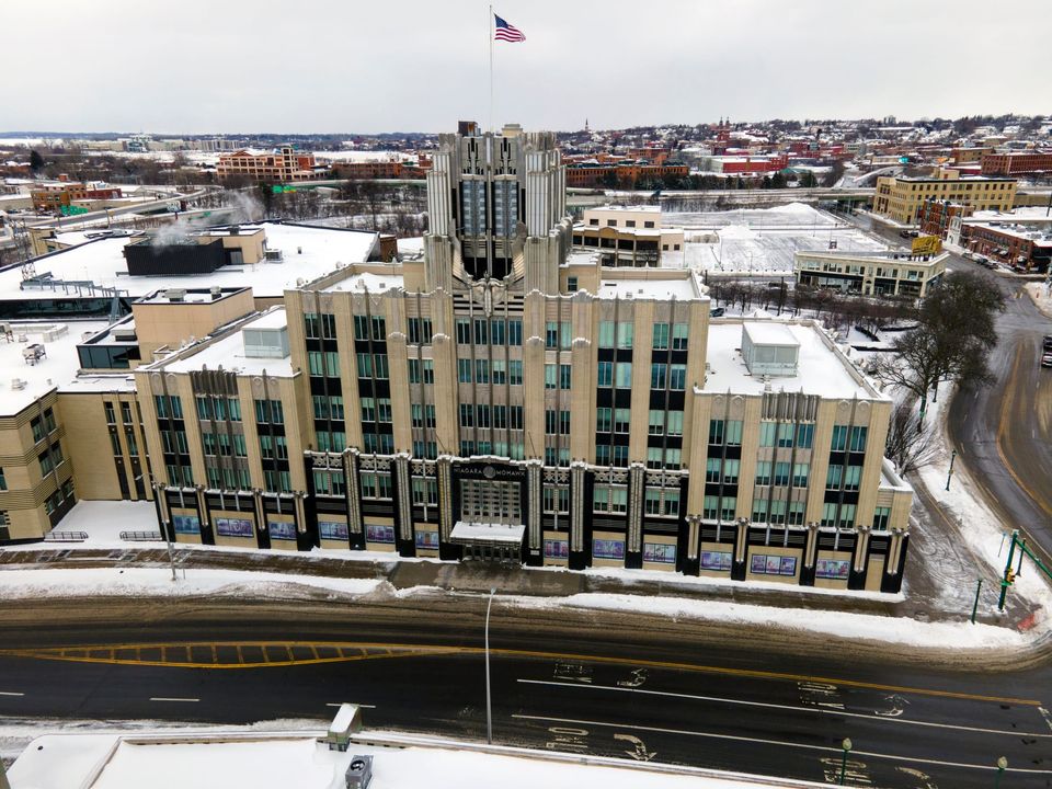 Snow-covered Niagara Mohawk Building in Syracuse, with an American flag flying above its Art Deco tower