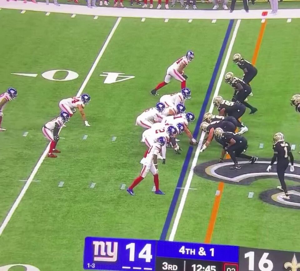 Giants and Saints players line up at the 40-yard line; the scoreboard shows 4th & 1, NY 14 and New Orleans 16