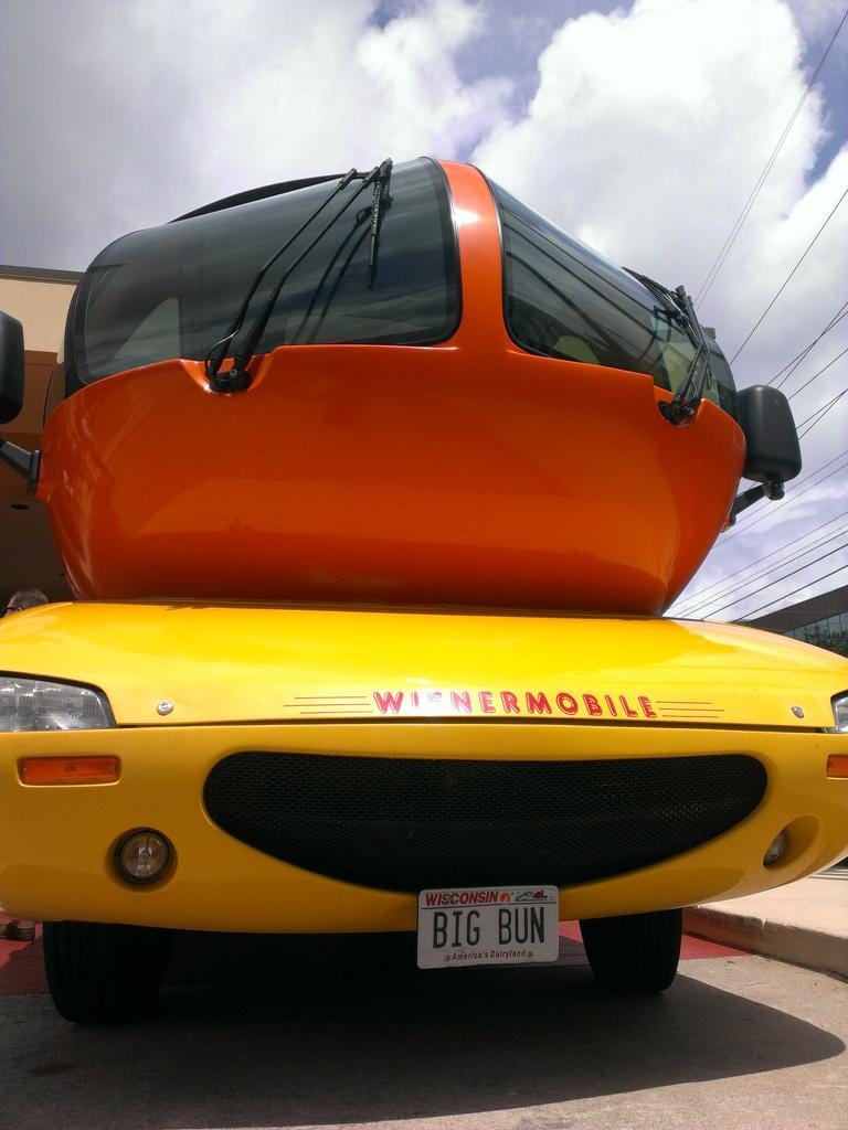 Low-angle front view of the Wienermobile with a Wisconsin license plate reading BIG BUN