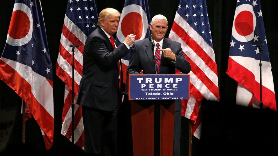 Donald Trump and Mike Pence at a Trump Pence podium in Toledo, Ohio, flanked by US and Ohio flags