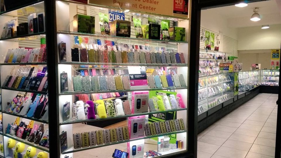 Store window packed with glittery, furry and Miami-branded phone cases on glass shelves