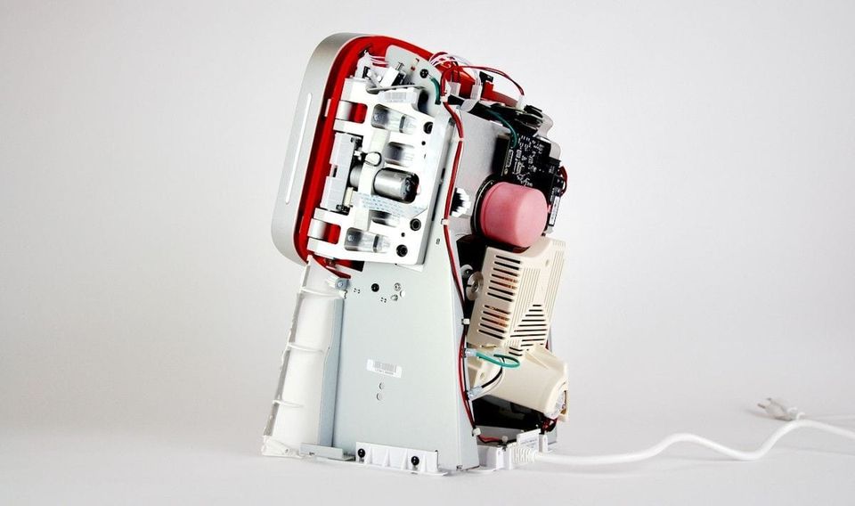 Disassembled Juicero press showing its aluminum frame, gears, motor and circuit boards inside