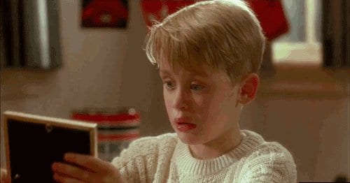 Kevin McCallister from Home Alone looking at a small framed picture with a stunned expression