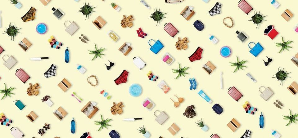 Pattern of consumer products like luggage, socks, underwear, bags and plants scattered on a pale yellow background
