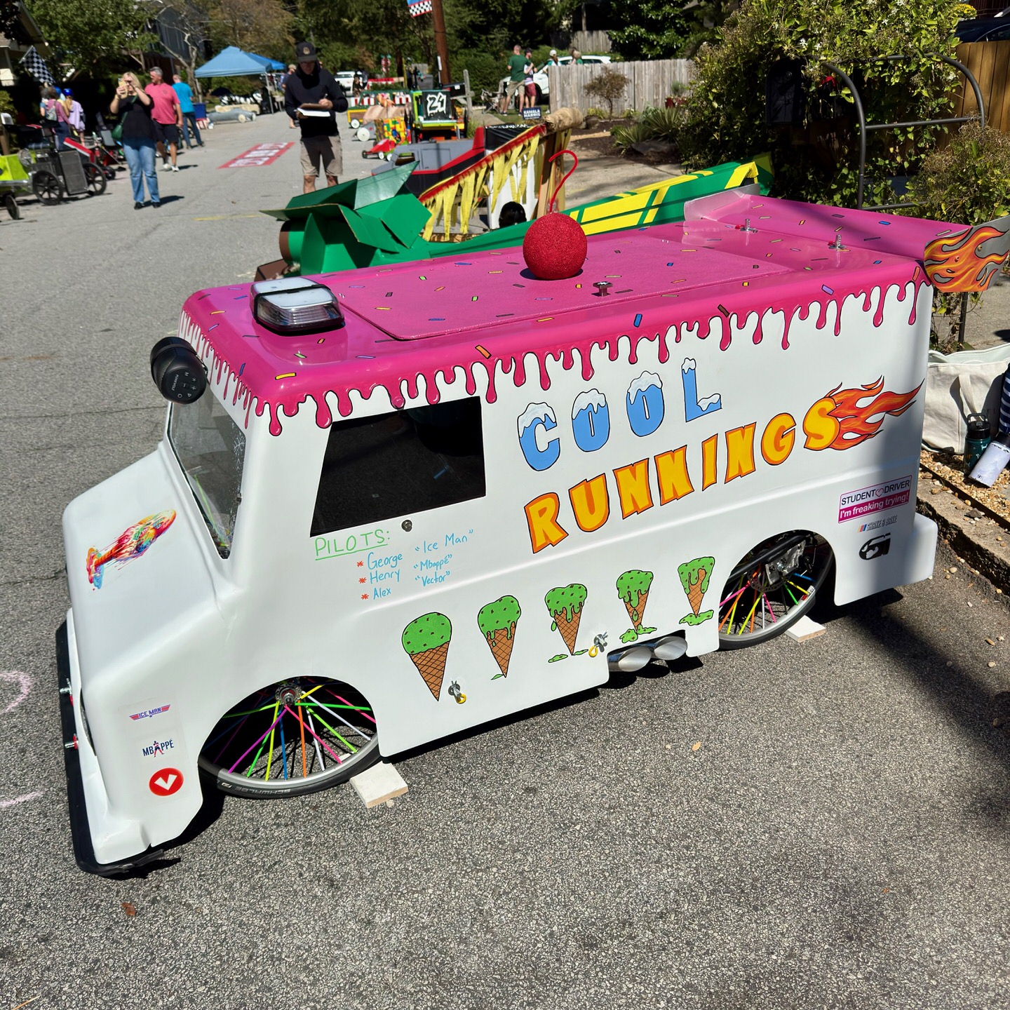 A "Cool Runnings" ice cream truck-themed soapbox derby car with pink dripping paint, ice cream cone graphics, and colorful spoke wheels