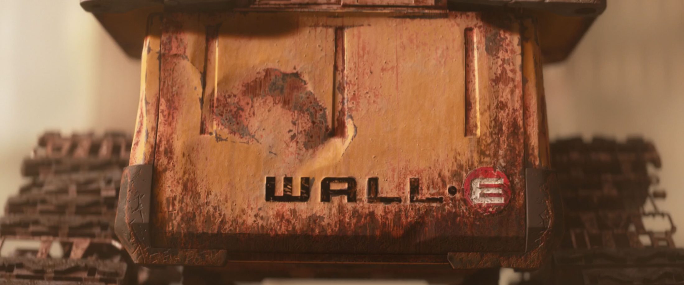 Close-up of the weathered, rust-covered body of the WALL·E robot with the name "WALL·E" printed on its front