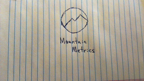Hand-drawn sketch on lined paper of a mountain inside a circle with the text "Mountain Metrics" written below